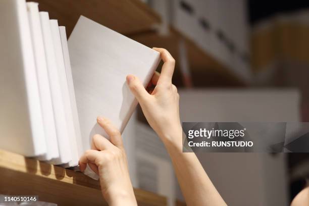 woman selecting book from shelf - choosing a book stock pictures, royalty-free photos & images