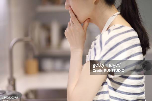 thoughtful housewife with hand on chin - matt japan stock-fotos und bilder