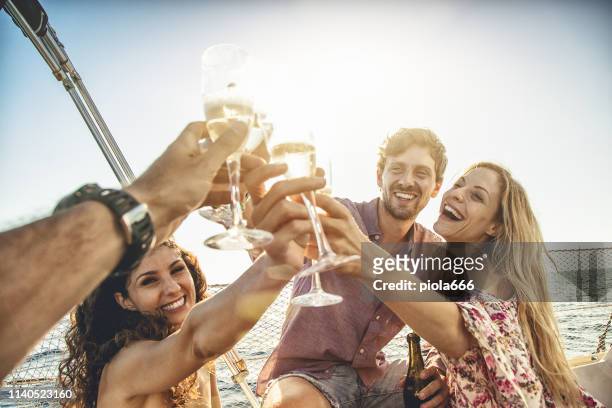 toasting tot in den sommer: segelboot-kreuzfahrt mit freunden - champagne toast stock-fotos und bilder