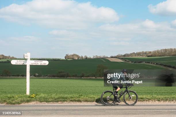 cyclist on country road - springtime exercise stock pictures, royalty-free photos & images