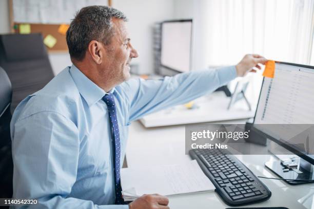 senior businessman working in office - sticky-notes-covering-computer-monitor stock pictures, royalty-free photos & images