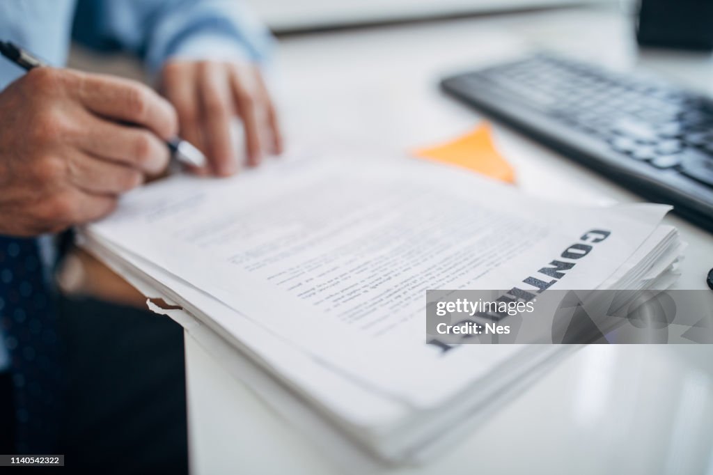 Businessman signing contract in office
