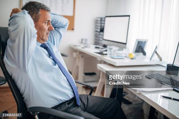concerned senior businessman in office - エコノミスト ストックフォトと画像