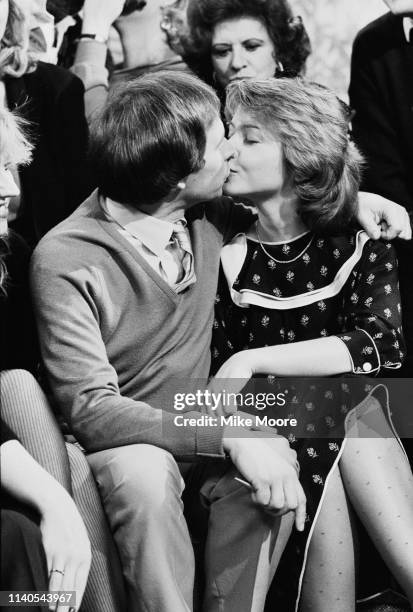 English journalists and broadcasters Nick Owen and Anne Diamond kissing in a television studio, UK, 1st February 1984.