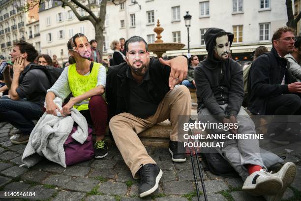 Protester wearing a mask depicting Alexandre Benalla, a French president's former bodyguard had been caught on video roughing up protesters during a...