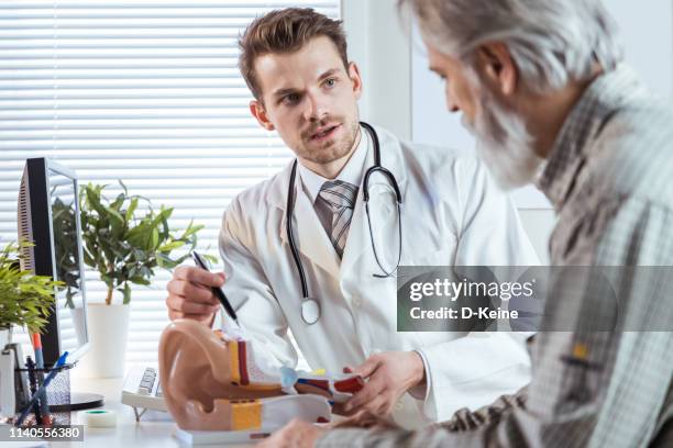 doctor consultating patient about deafness - human ear stock pictures, royalty-free photos & images