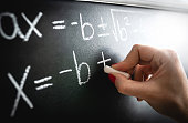 Math equation, function or calculation on chalkboard. Teacher writing on blackboard during lesson and lecture in school classroom. Student calculating or professor working.