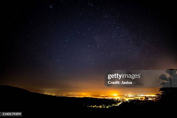 starry night sky in hungary with light pollution - photopollution stock-fotos und bilder