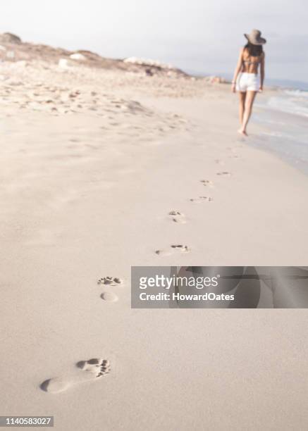 woman walking on beach leaving footprints in sand - formentera stock pictures, royalty-free photos & images