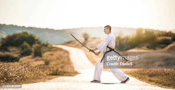 young martial artist öva sina färdigheter med en katana svärd. - sword bildbanksfoton och bilder