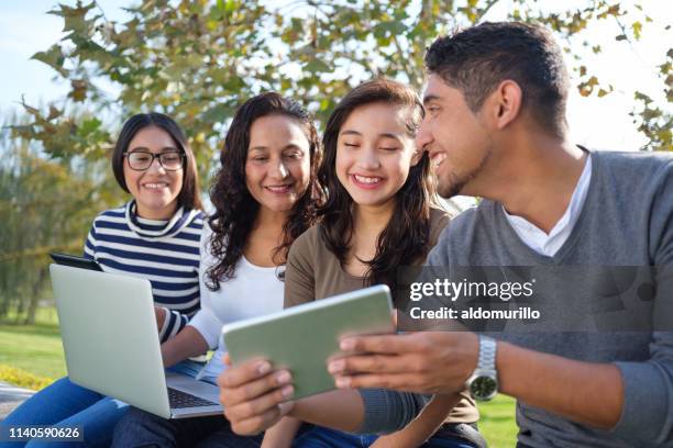 young man sitting with family and using tablet - mother and son using tablet and laptop stock pictures, royalty-free photos & images