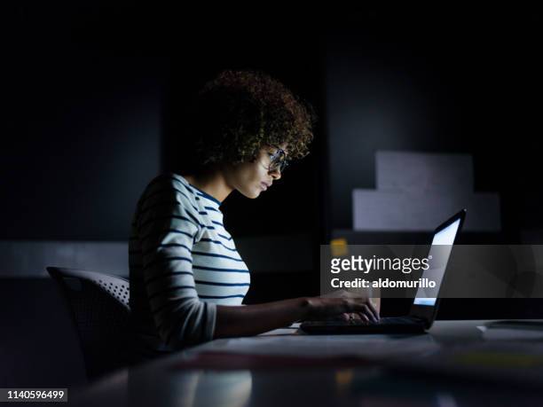 concentrated businesswoman working late hours with her laptop - concentration stock pictures, royalty-free photos & images
