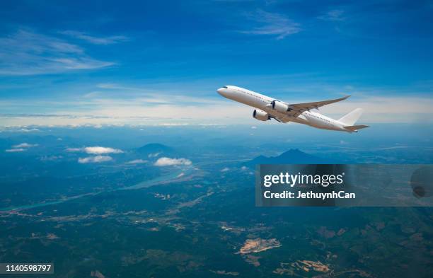 commercial airplane flying above the mountain and river scenery - airplane in sky stock pictures, royalty-free photos & images