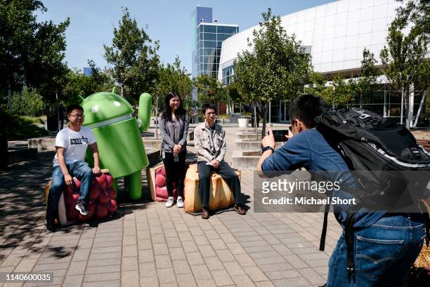 Tourists pose with an Android character on the Google campus as Google workers inside hold a sit-in to protest sexual harassment at the company, on...