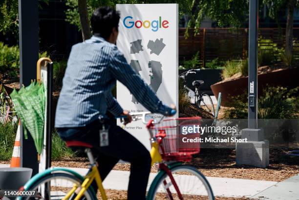People ride bikes past signage on the Google campus as Google workers inside hold a sit-in to protest sexual harassment at the company, on May 1,...