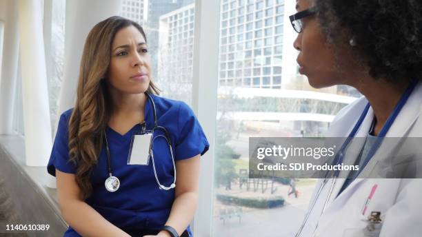 two female doctors have serious conversation - nurse conflict stock pictures, royalty-free photos & images