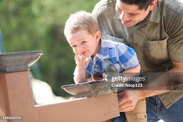 little boy, father playing at local park, water fountain. - drinking fountain stock pictures, royalty-free photos & images