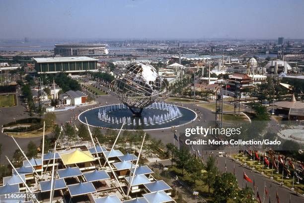 Birds-eye view of the Unisphere and various exhibition pavilions, with Flushing Bay and urban sprawl in the background, New York Worlds Fair,...