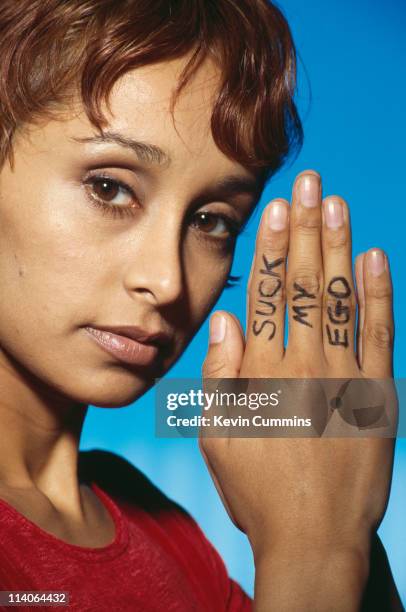 Sonya Madan, singer with the Britpop band Echobelly, posing with 'suck my ego' written on her hand, circa 1998.