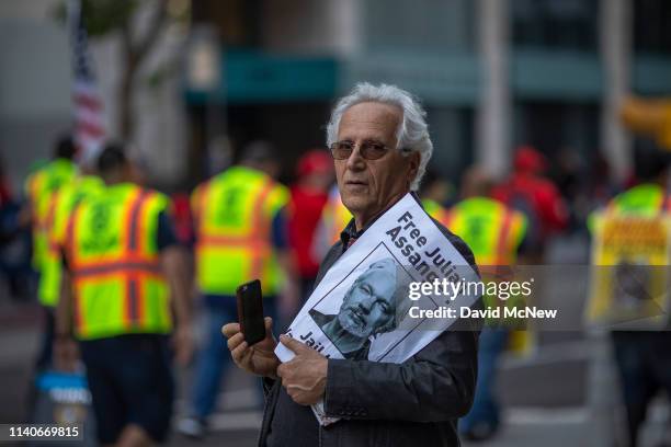 Man holds a sign calling for the release of Julian Assange as people march and rally on May Day, also known as International Workers Day, on May 1,...