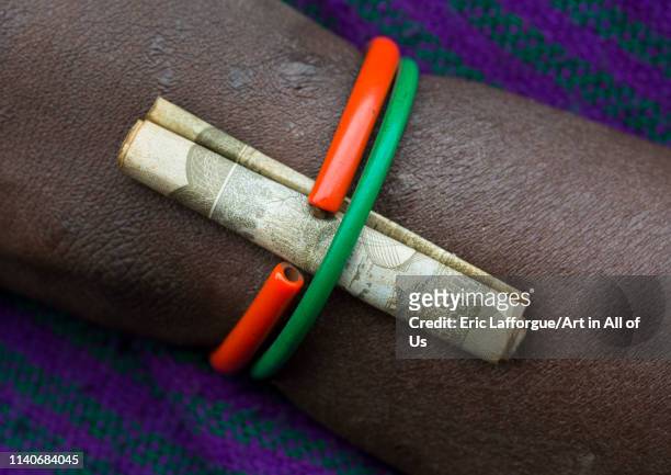 Detail of a bracelet with a birr note on a Suri tribe woman, Kibish, Omo valley, Ethiopia on July 2, 2012 in Kibish, Ethiopia.