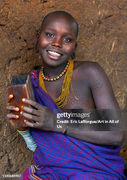 Smiling Suri tribe woman holding a kalimba, Kibish, Omo valley, Ethiopia on July 2, 2012 in Kibish, Ethiopia.