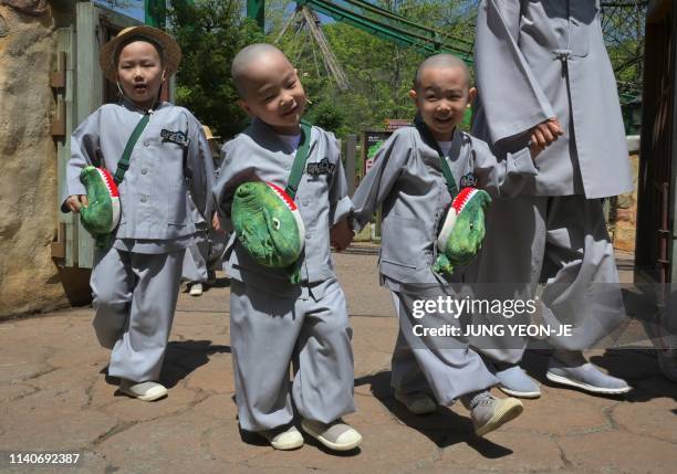 South Korean children monks walk around an amusement and animal park during their training program learning about Buddhism in Yongin, south of Seoul,...