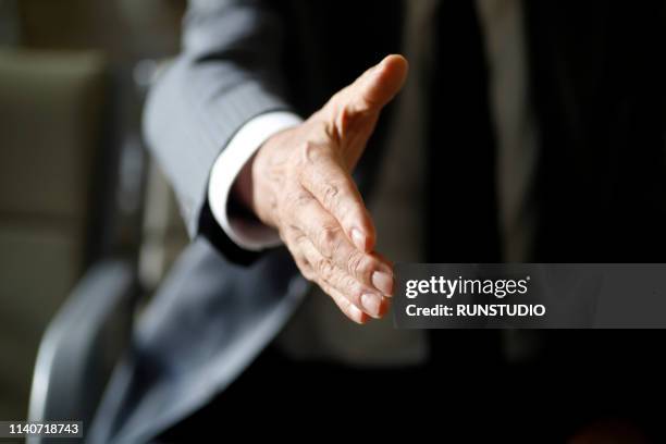 senior businessman offering handshake - handshake closeup stock-fotos und bilder