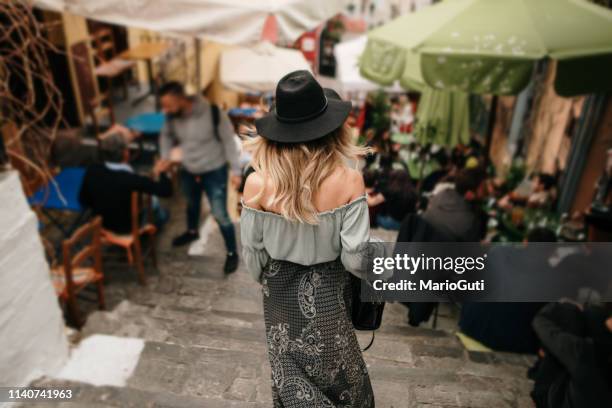 rear view of young tourist in a street in greece - athens restaurant stock pictures, royalty-free photos & images