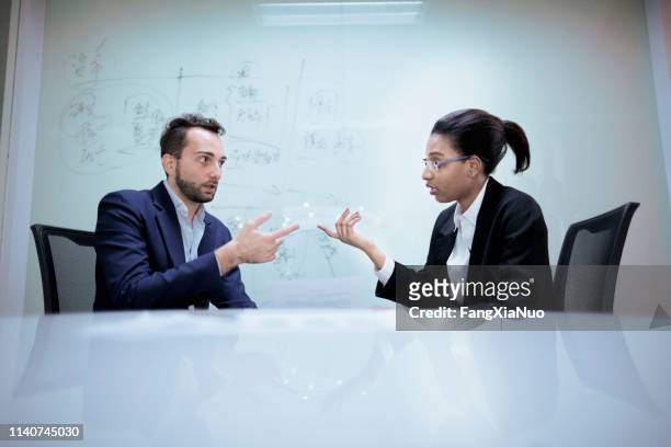 pair of office colleagues discussing future plans - debate imagens e fotografias de stock