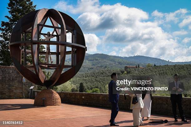 Asian tourists stand by a wooden representation of the Vitruvian Man , a circa 1490 drawing by Leonardo Da Vinci in which he represented a man with...
