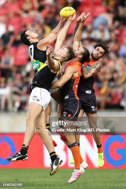 Daniel Rioli and Noah Balta of the Tigers competes for the ball against Phil Davis and Zac Williams of the Giants during the round three AFL match...