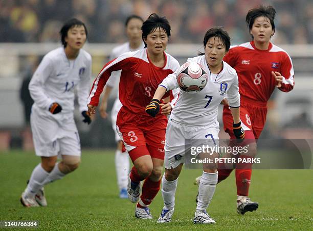 Cho So Hyun of South Korea is chased down by Om Jong Ran and Kil Son Hui of North Korea in their final match in the East Asian Women's Football...