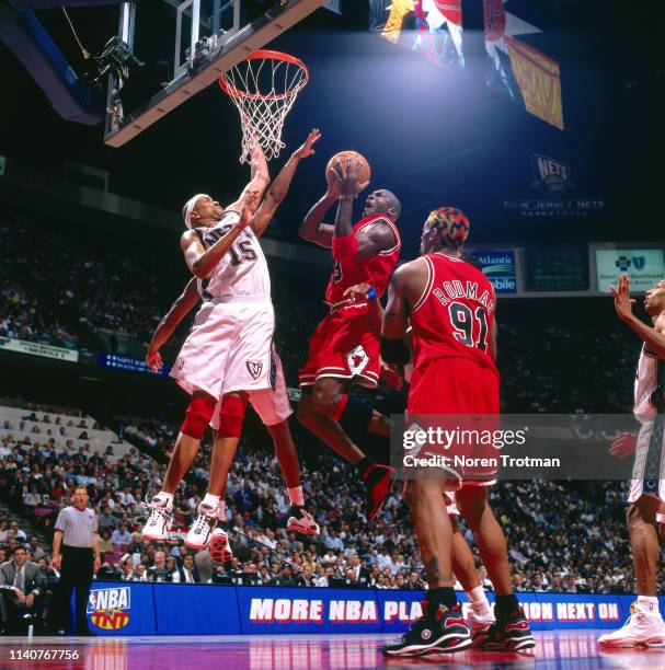 Michael Jordan of the Chicago Bulls shoots the ball against Chris Gatling of the New Jersey Nets during Game Three of Round One of the 1998 NBA...