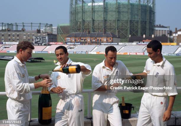 England cricketers Mike Atherton, Adam Hollioake, Nasser Hussain and Ben Hollioake pose for photos with bottles of champagne from sponsor Veuve...