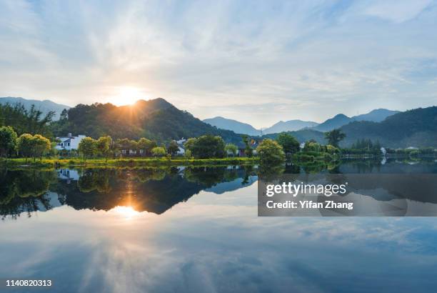 idyllic mountain village reflection under sunset - provincia di anhui foto e immagini stock