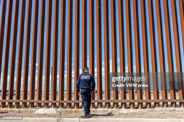 An officer of the Mexican Federal Police stands next to the US-Mexico Border Fence on April 5, 2019 in Mexicali, Mexico. President Trump on Friday...