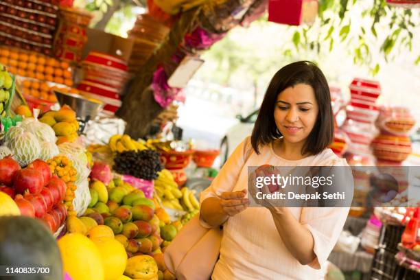 vrouw het kopen van fruit op de markt van de landbouwer - raw mango stockfoto's en -beelden