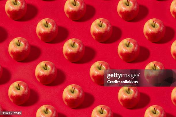 apple fruit pattern on red background - apples overhead stock pictures, royalty-free photos & images