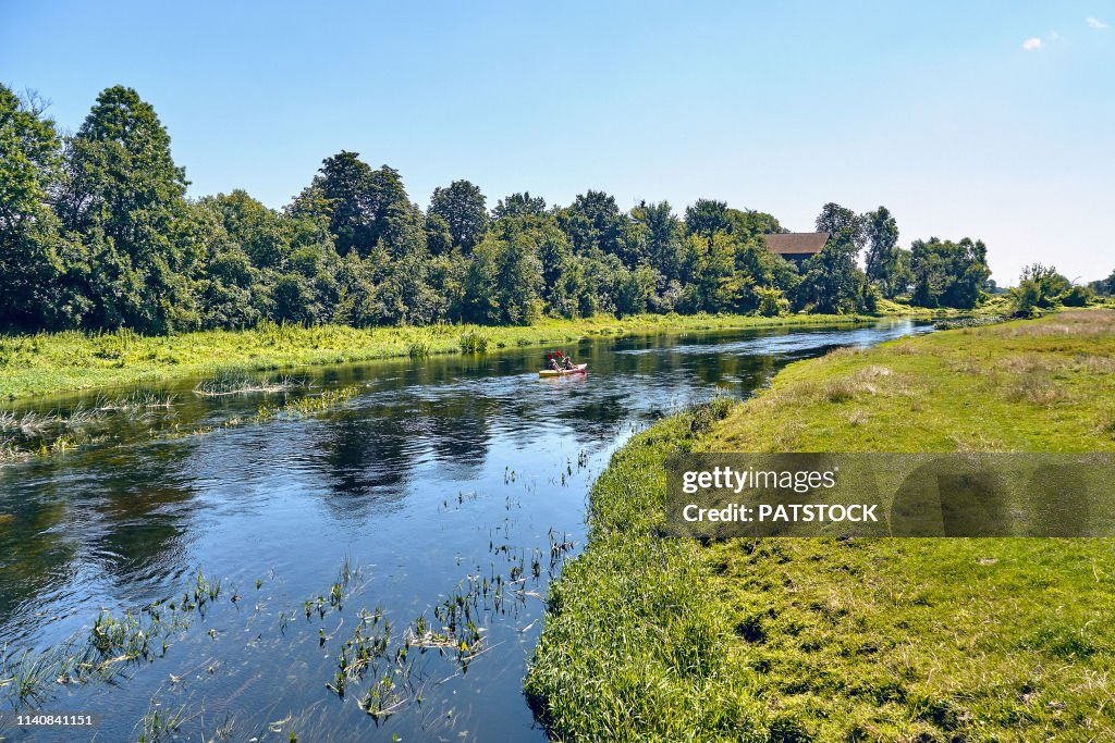 Tourists kayaking on Wkra river during sunny weekend