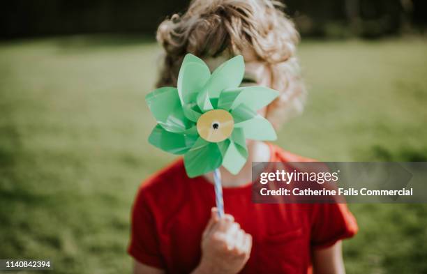 little boy holding windmill - energieeffizienz stock-fotos und bilder