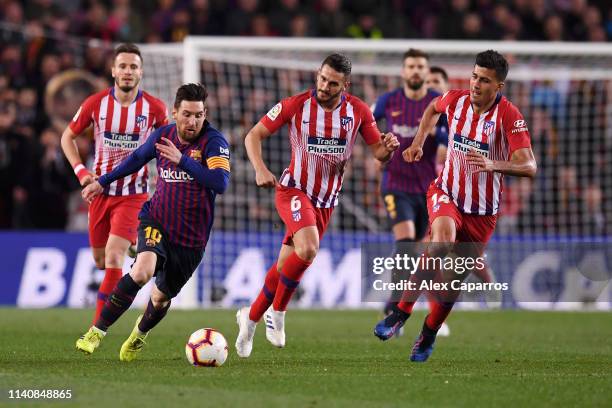 Lionel Messi of Barcelona is chased by Rodri and Koke of Atletico Madrid during the La Liga match between FC Barcelona and Club Atletico de Madrid at...