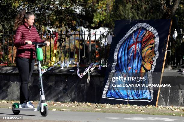 Woman rides past an art tribute of a Mauri woman with headscarf designed with New Zealand's national flag, outside the Botanical Gardens in...