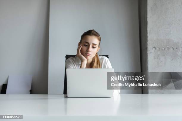 bored businesswoman working on laptop - bored worker fotografías e imágenes de stock