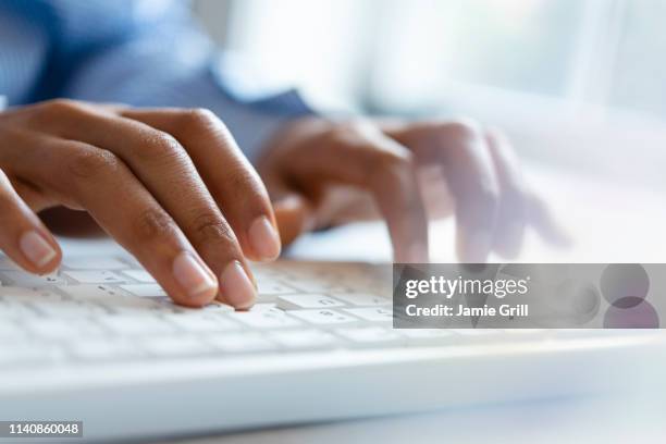hands of young woman typing on computer keyboard - typing stock-fotos und bilder