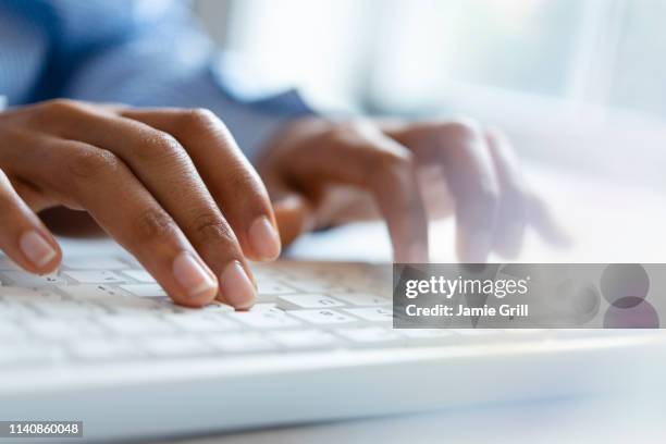 hands of young woman typing on computer keyboard - typing fotografías e imágenes de stock