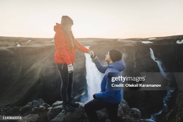 young man proposing to his girlfriend while hiking by haifoss waterfall in iceland - engagement bildbanksfoton och bilder