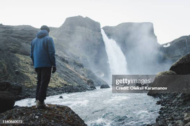 hiker by haifoss waterfall in iceland - blaue jacke stock-fotos und bilder