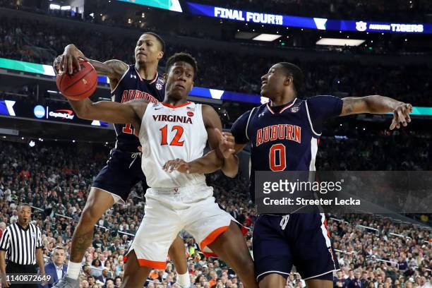 De'Andre Hunter of the Virginia Cavaliers battles for the ball with J'Von McCormick and Horace Spencer of the Auburn Tigers in the second half during...