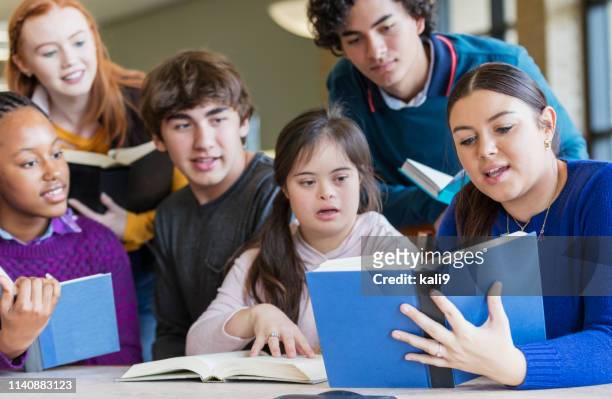 Teenage girl with down syndrome and friends reading